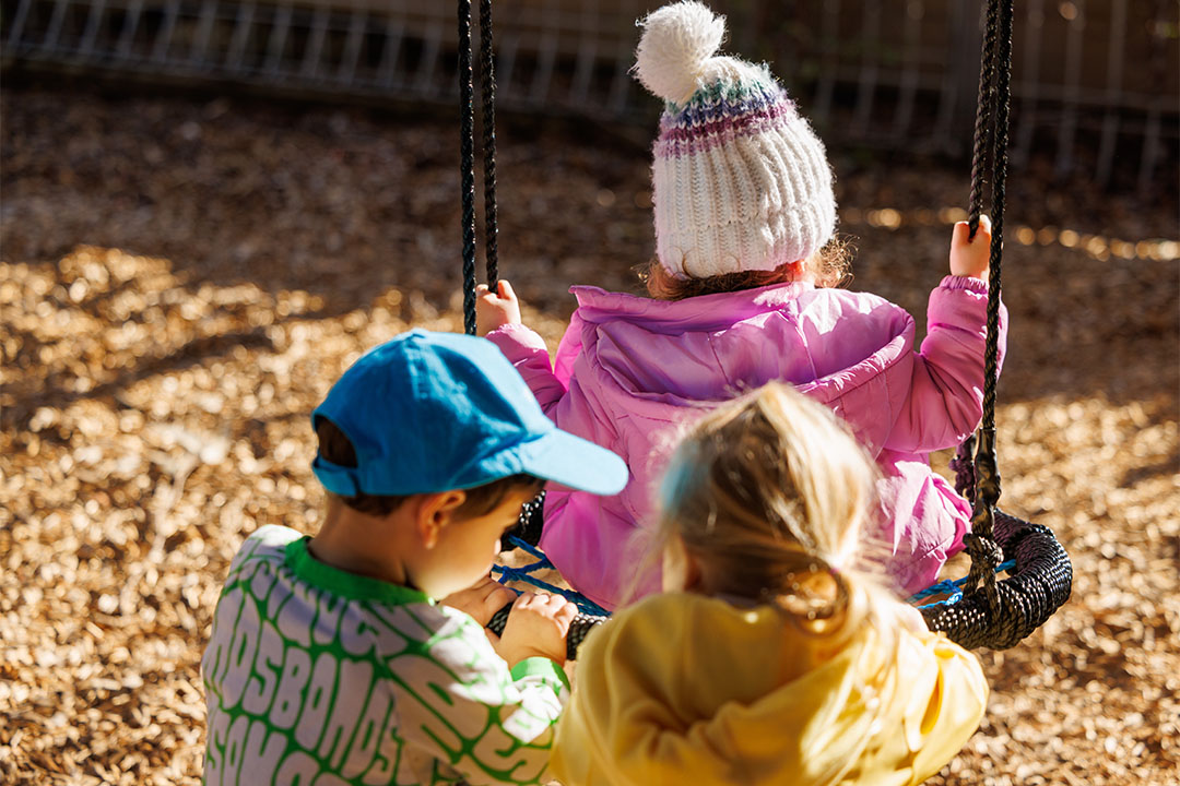 Three children swing childcare